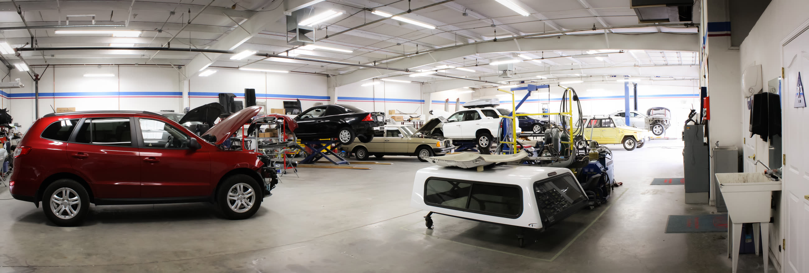 Panorama of the California Color repair floor in Chico, with several vehicles under repair.